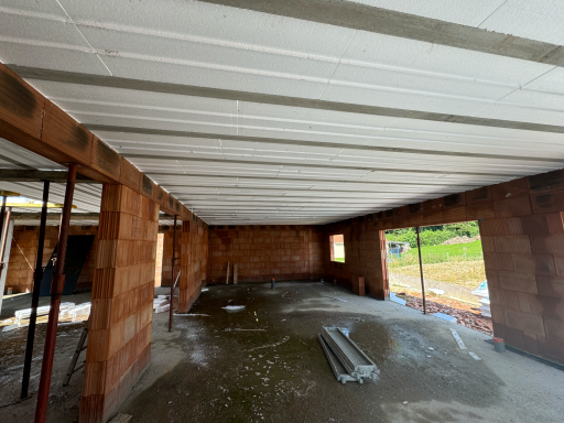 poutrelles hourdis Intérieur d'un bâtiment en construction avec des murs en briques et des poutres au plafond.