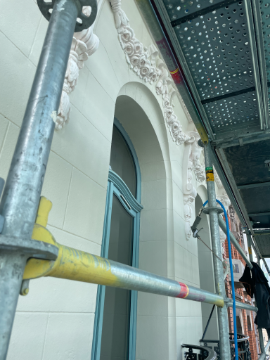 Scaffolding autour d'une façade avec des détails architecturaux en cours de rénovation.