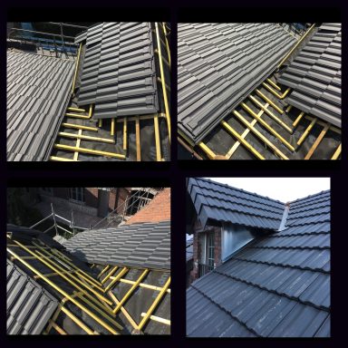 Toits en tuiles grises en cours de pose, avec structures de soutien en bois apparentes.